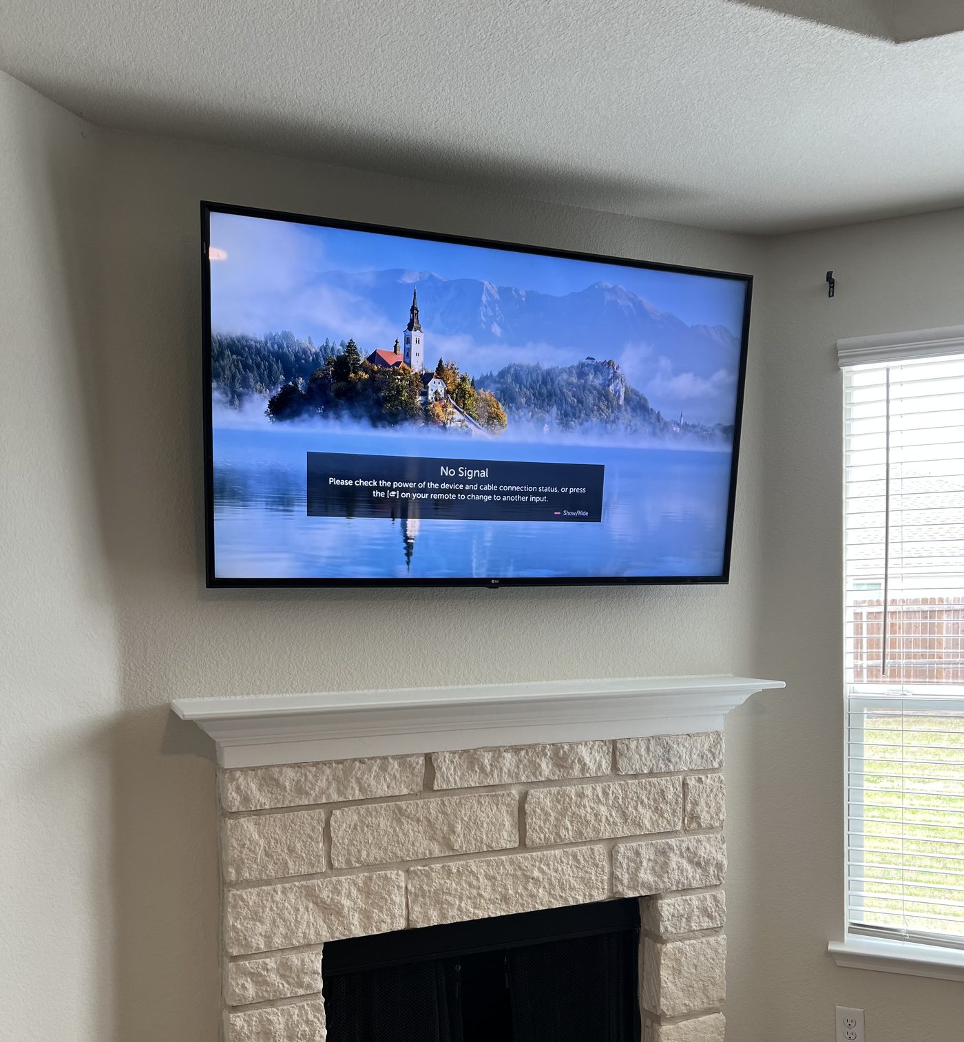 TV mounted above brick fireplace in Dallas TX home - EZ TV Mounting